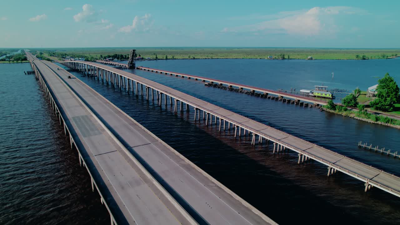 A highway and freight rail bridge form a vital economic artery, immense scale of modern logistics and commerce. Luisiana, USA
