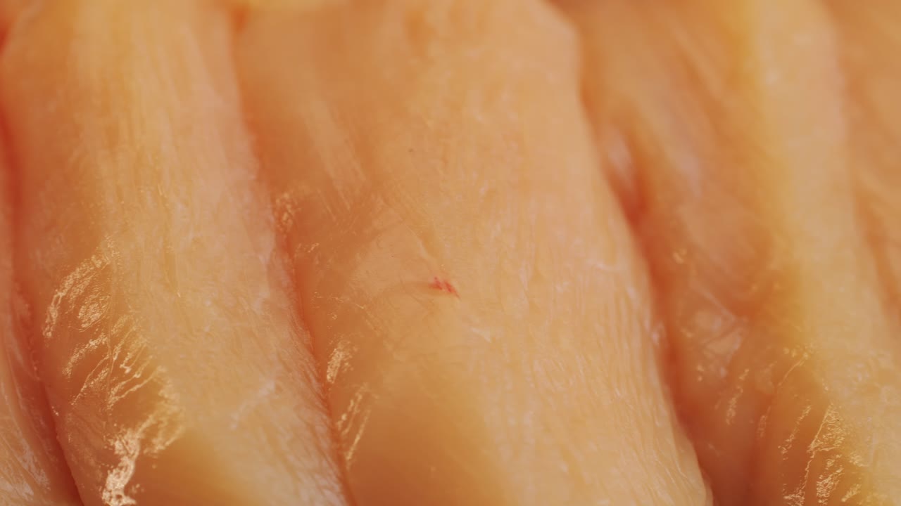 Cutting with knife raw chicken meat on desk close-up. Preparing raw food for cooking. Grilled chicken, duck, turkey kebab with vegetables.