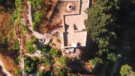 aerial view of ancient stone structures and a well amidst arid landscape