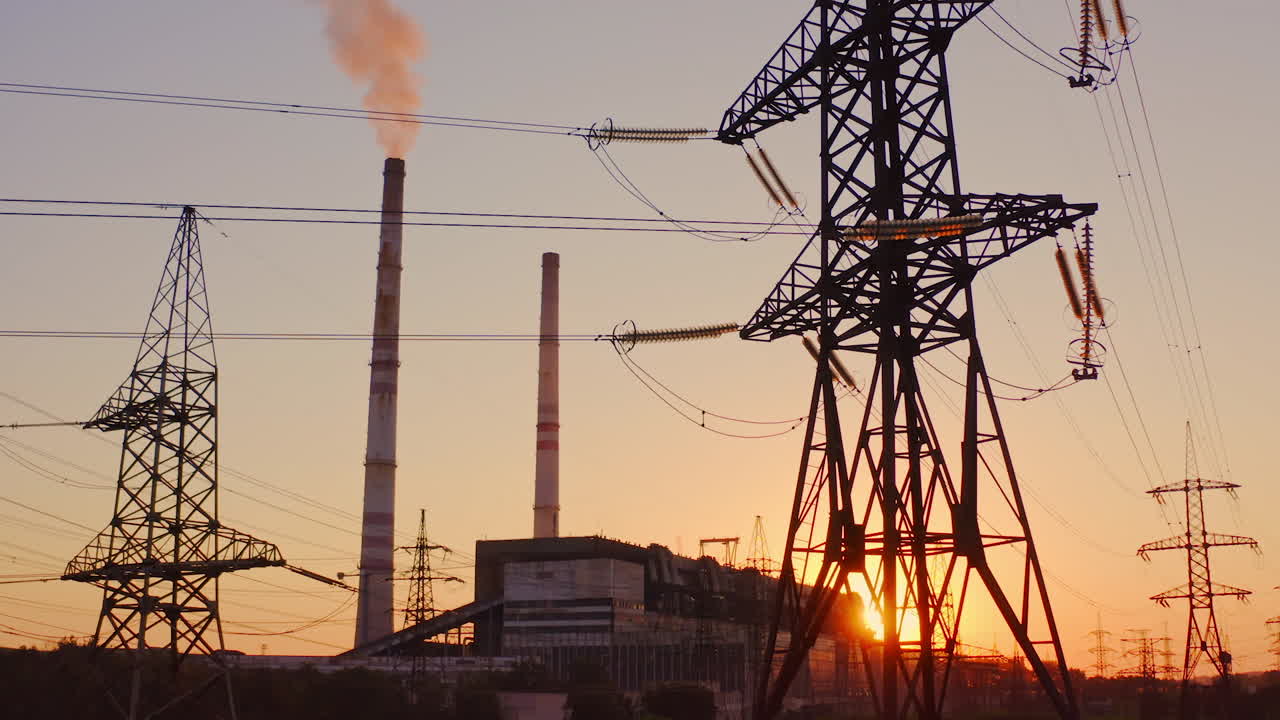 Beautiful sunset over power lines. High voltage power tower landscape at sunset