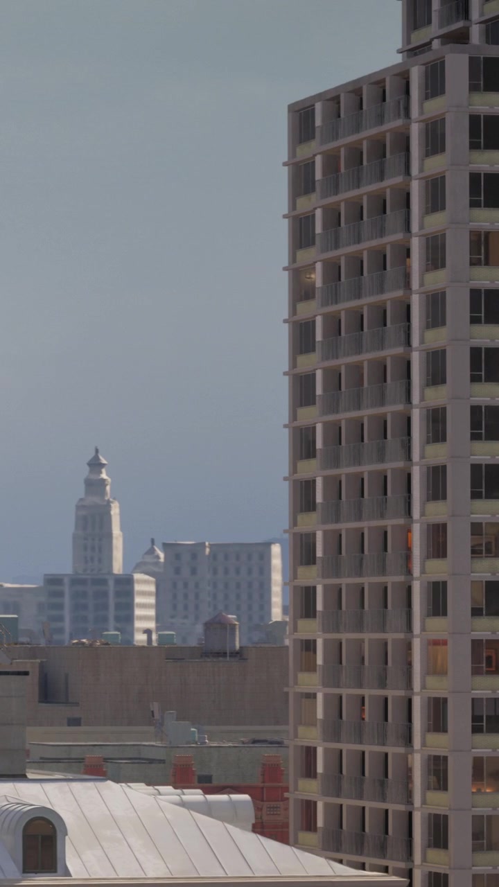 Edificios altos y una torre de agua en una ciudad por la tarde.