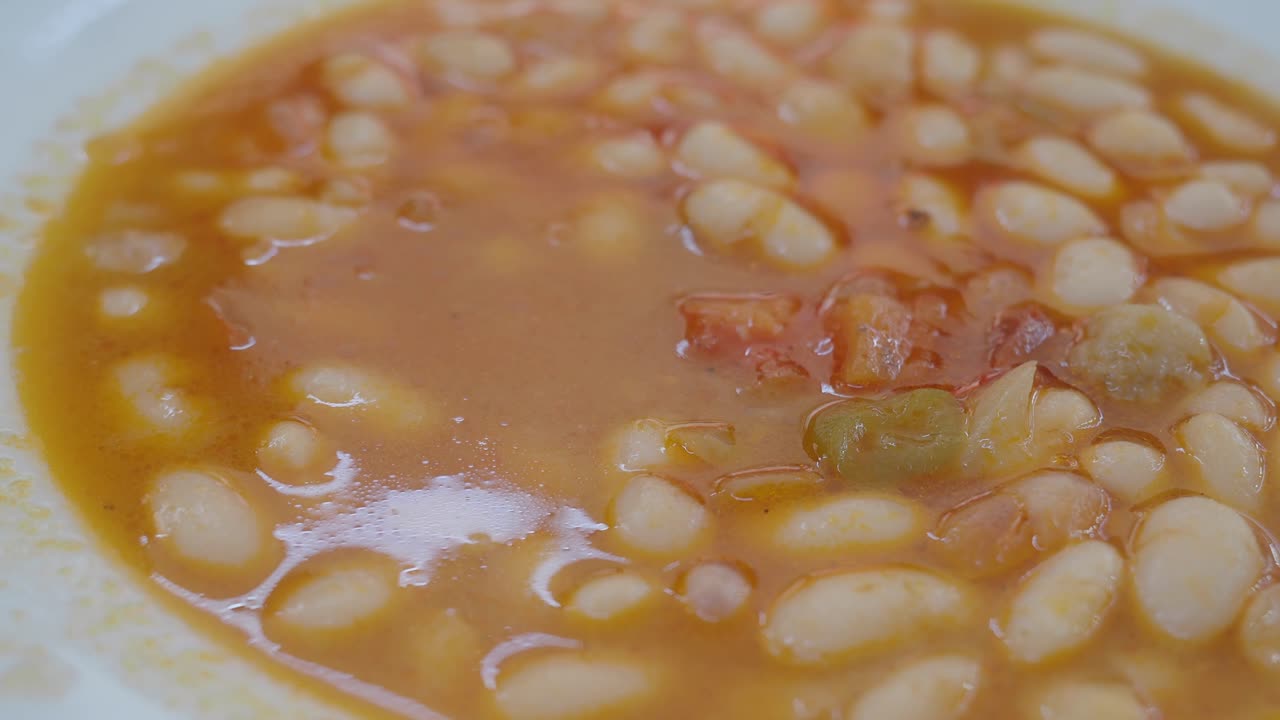 Scooping Hearty White Bean Stew from a Bowl