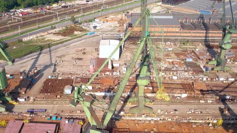 vista aérea del carro a través de grandes grúas verdes en el astillero de gdansk, polonia