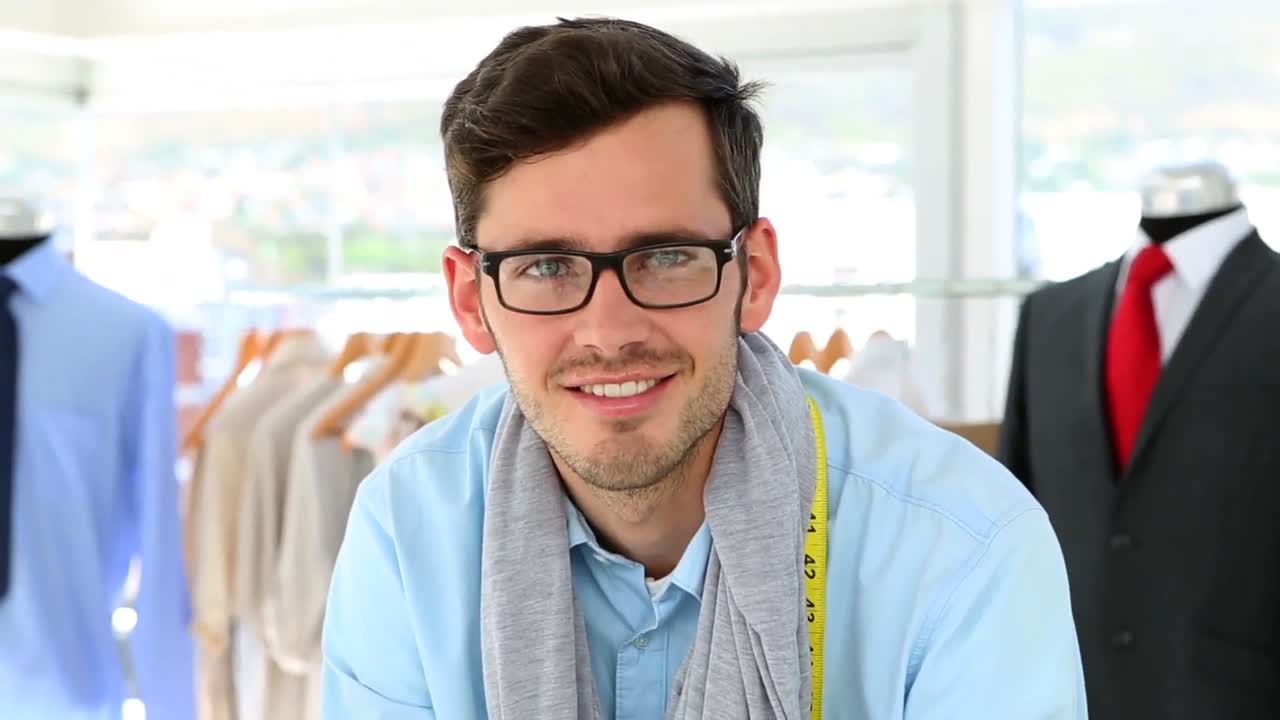un guapo diseñador de moda sonriendo a la cámara