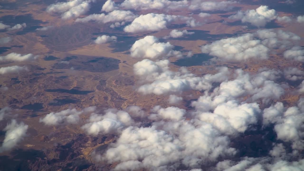 Stunning aerial footage captured by aircraft flying over barren terrain in Jordan. Features rugged desert landscapes, dry valleys, and rocky formations under warm natural light