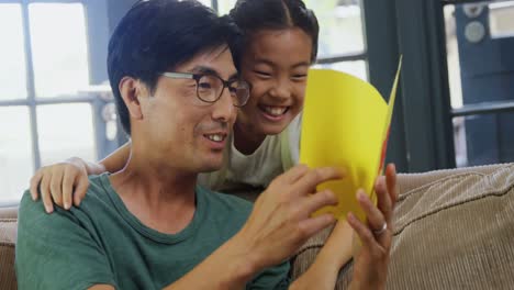 Padre-E-Hija-Leyendo-Tarjetas-De-Felicitación-En-La-Sala-De-Estar-4k