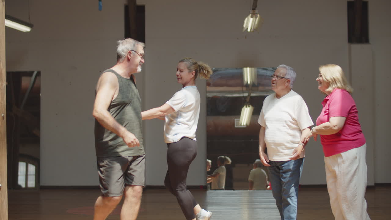 볼룸에서 춤추는 행복한 노인 남녀의 긴 샷