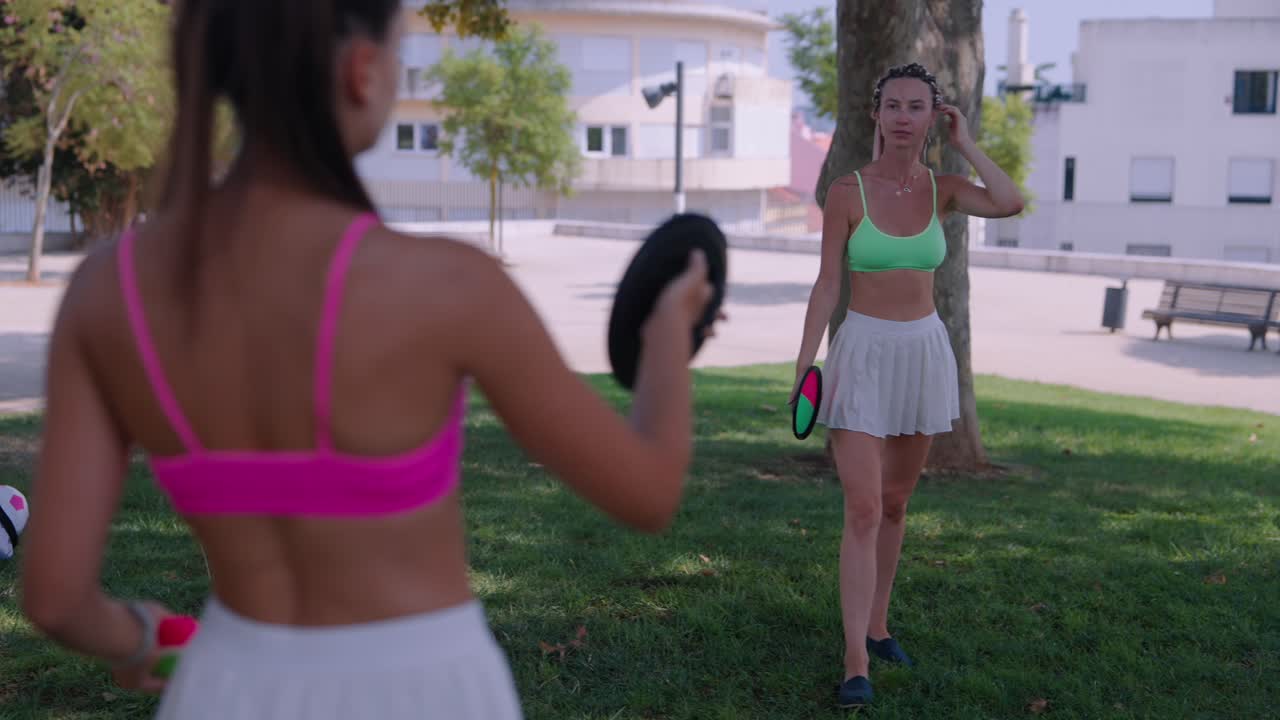 Two women playing frisbee in the park