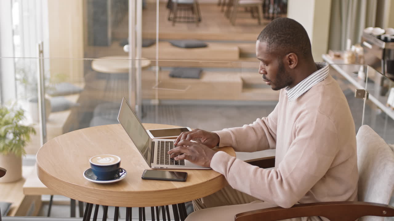 African-American Businessman Working on Laptop in Cafe
