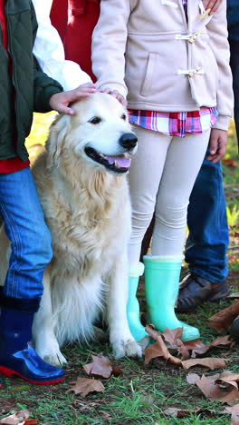 familia de pie en el parque con su perro
