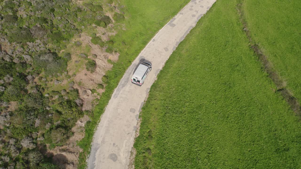 포르투갈 보르데이라(bordeira)의 구불구불한 도로를 따라 운전하는 캠퍼 밴에 대한 공중 조감도