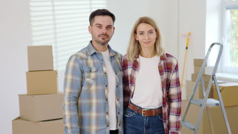 una pareja feliz pintando su nueva casa.