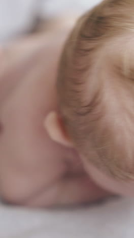 professional nurse hands practice hypertonus back massage on lying on stomach infant boy and raises baby close view