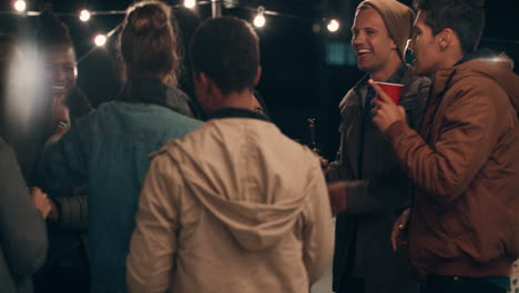 multi ethnic group of friends having fun dancing to music on rooftop at night enjoying celebration party