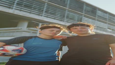 portrait of two young female soccer players on the street