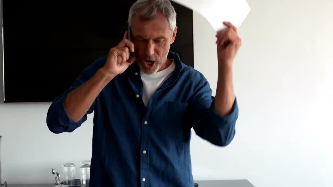 ejecutivo frustrado hablando por teléfono móvil