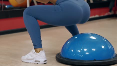 slow motion close girl in blue leggings jumps and sit-ups