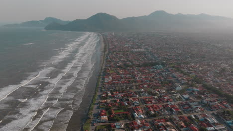 aerial view of coastal city with beach and mountains