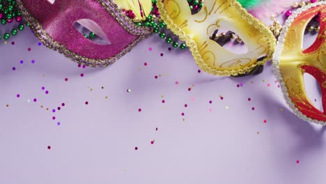 video of carnival masquerade masks, feathers, confetti and mardi gras beads, with copy space