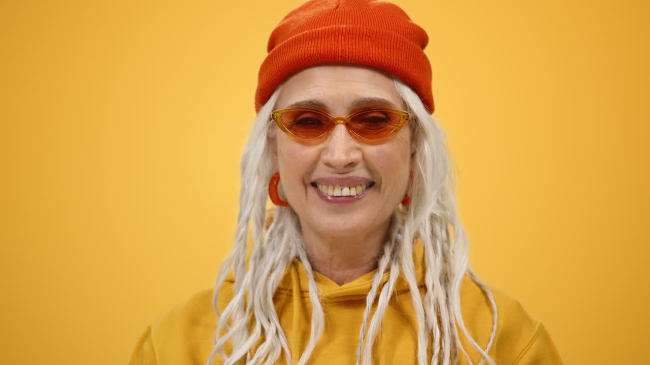 una anciana sonriente disfrutando del ocio en el interior. una mujer madura mirando la cámara en el interior.