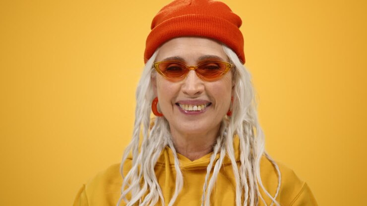 Smiling old woman enjoying leisure inside. Mature lady looking camera indoors.