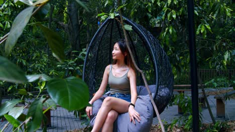 Malaysian Woman Sitting In A Swing Chair Outdoors, SLOW MOTION