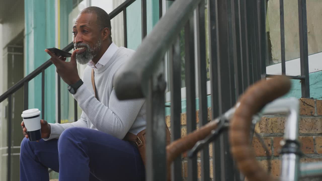 African American man drinking a coffee and using his phone
