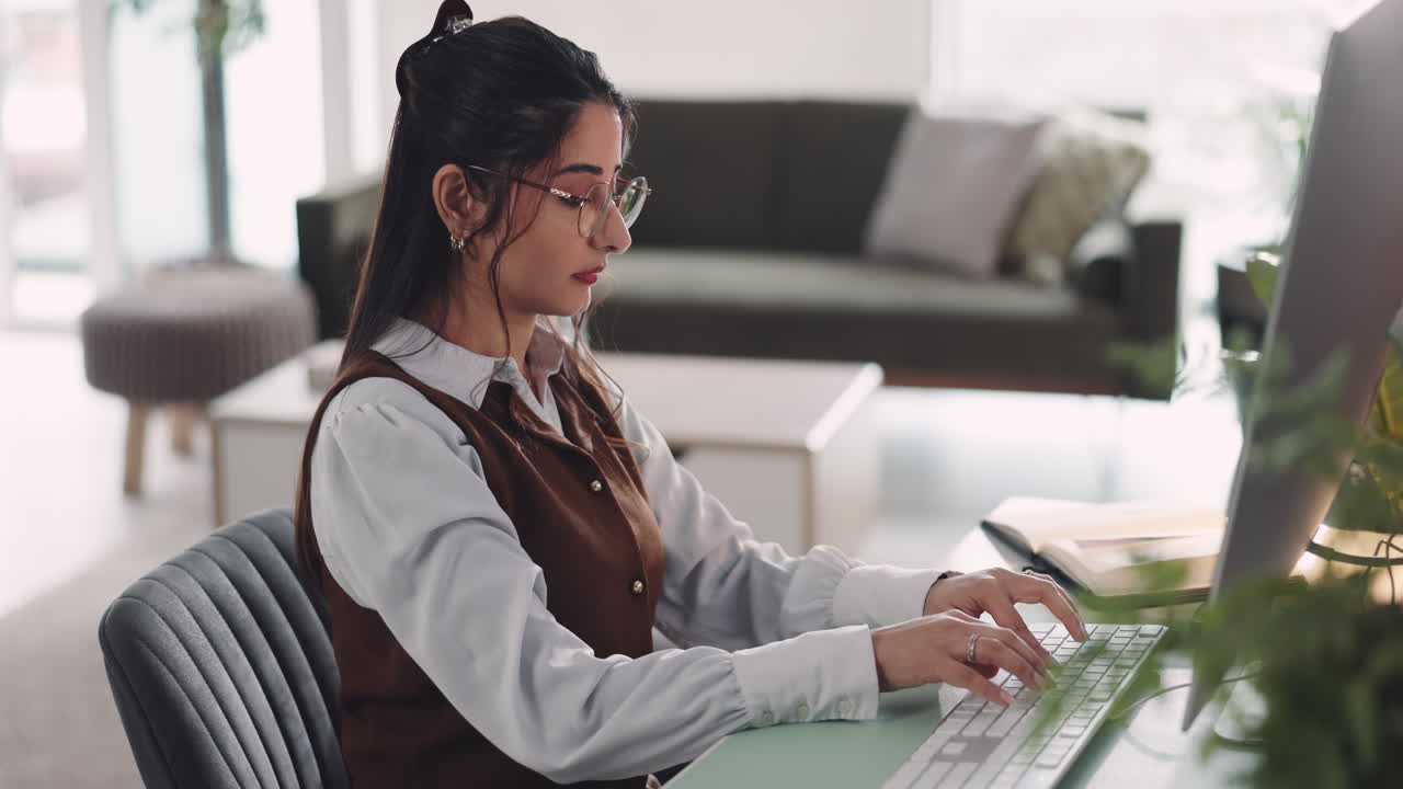 Woman typing on a computer in a home office