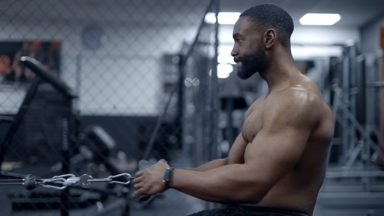 Athletic African American man doing Seated cable rows side angle