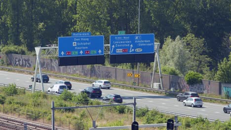 road signs above vehicles driving on a10 motorway in amsterdam, netherlands