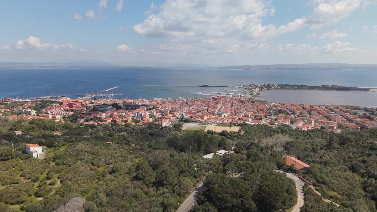 İtalya, Sardinya'daki San Pietro Adası'nda, Carloforte'ye bakan dağ yürüyüş parkurları. Kasabayı çevreleyen kıyı manzarası. Havadan yükselen çekim.