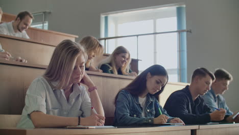 a group of students listening to a lecture at the university from a professor. large audience for college lectures.