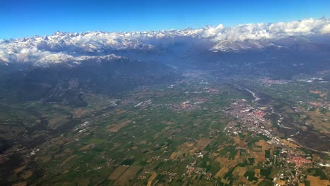 Luftaufnahmen-Eines-Grünen-Tals-Unter-Den-Schneebedeckten-Alpen