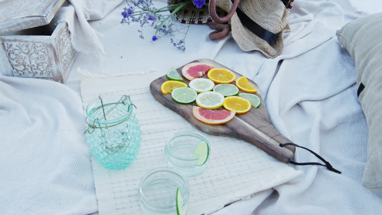 Luxury picnic set up for a romantic date with citrus fruits and accessories at the beach - Close Up Shot
