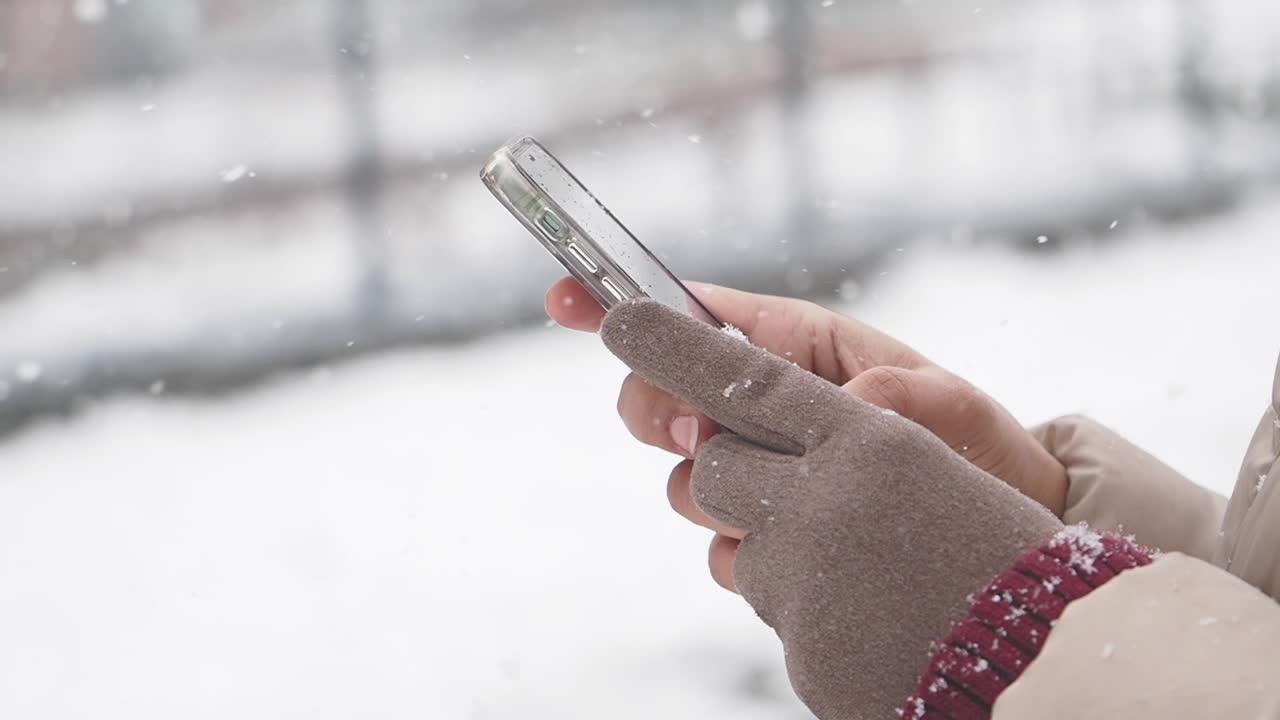 Person using phone in the snow