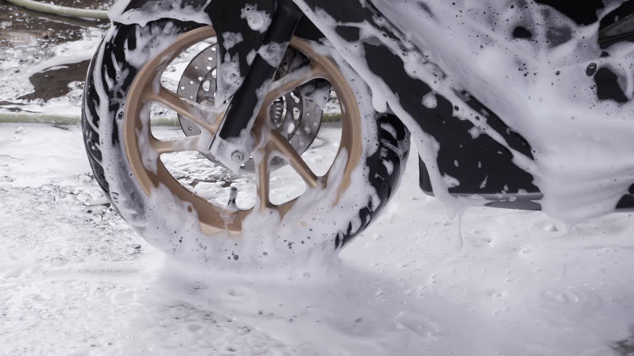 Slow motion of scooter wheel covered in soap and foam