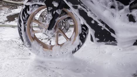 slow motion of scooter wheel covered in soap and foam