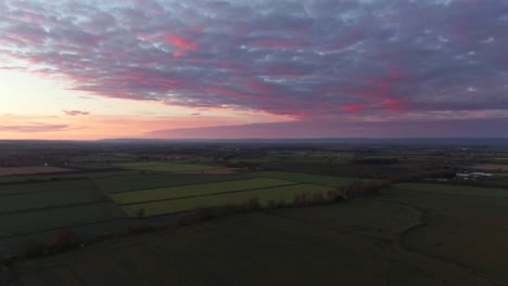 drone parallax of purple moody sunset over cloudy english countryside