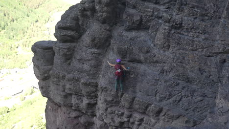 young woman on adventurous climbing route moving on steep cliff using ropes and cables