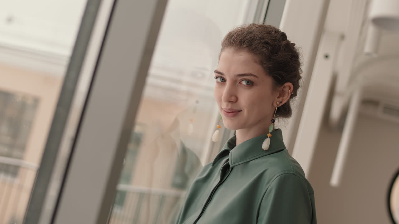 una mujer sonriendo por la ventana.
