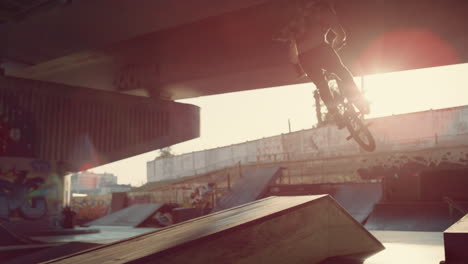 Active-bmx-rider-performing-trick-during-freestyle-session-at-skate-park.