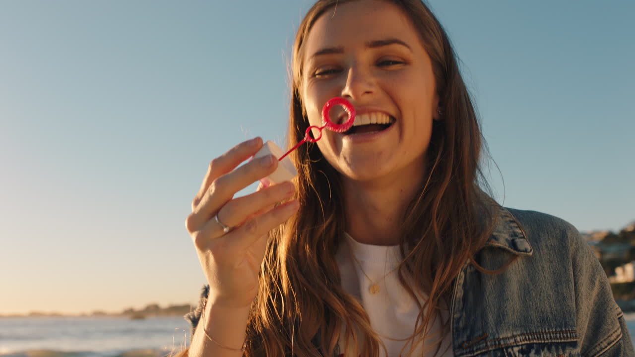 adolescente soplando burbujas en la playa al atardecer divirtiéndose en vacaciones junto al mar disfrutando del verano