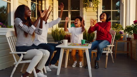 happy family playing a board game on the porch