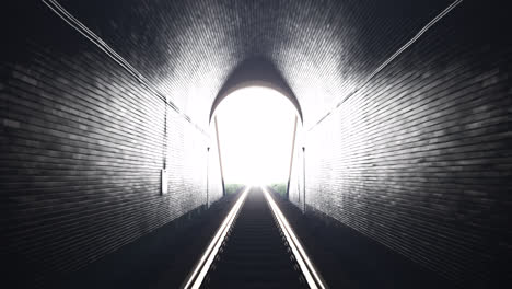 train leaving an old underground tunnel. a camera placed in the train driver cabin. moving through a railway tunnel towards the light. cargo logistics. railway underground transportation.