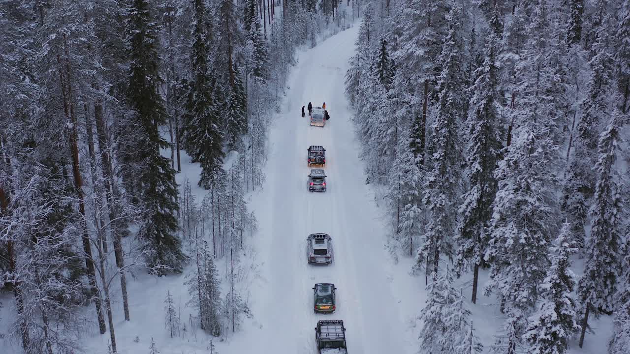 coches atascados en una carretera de campo traviesa cubierta de nieve que atraviesa laponia durante el solsticio de invierno