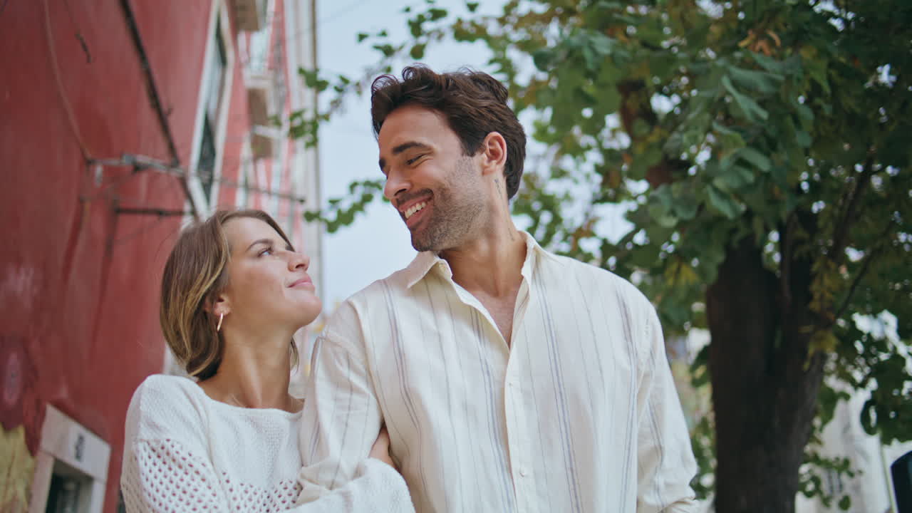 행복 한 부부 가 구름 은 여름 날 에 도시 거리 를 따라 함께 고 있다