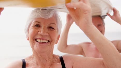 Retired-couple-holding-surfboard-over-their-heads