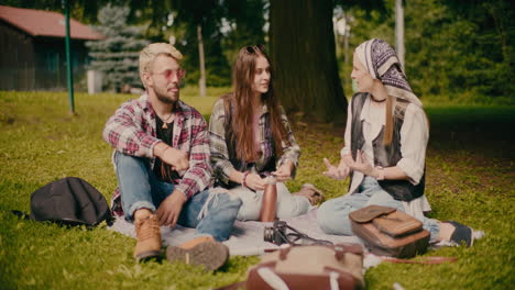 man and woman talking with female friend at picnic