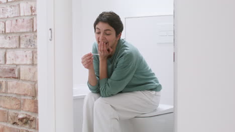 Frau-Mit-Schwangerschaftstest-Im-Badezimmer