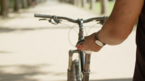 un primer plano de las manos del hombre sosteniendo el asiento de la bicicleta